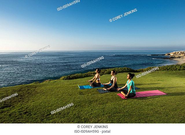 Women on cliff, meditating