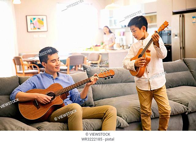 Father and his son in playing the guitar