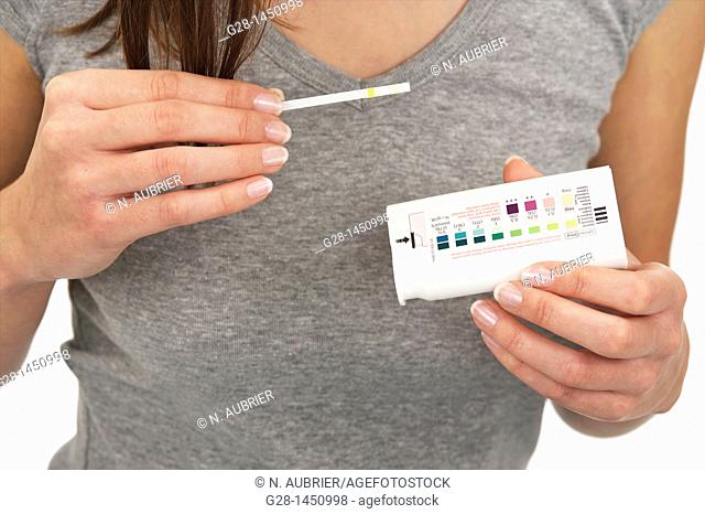 woman holding a urine analysis self test to test glucose for diabetes