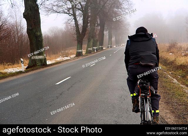 rider in the mist, fog on the road, a foggy morning, country route in the fog