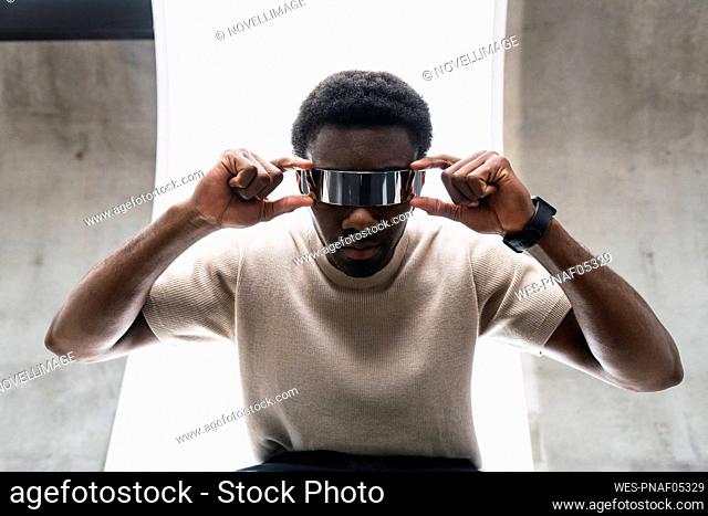 Young man adjusting cyber glasses