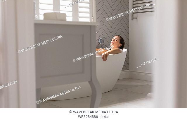 Woman relaxing in the bathtub in bathroom at home