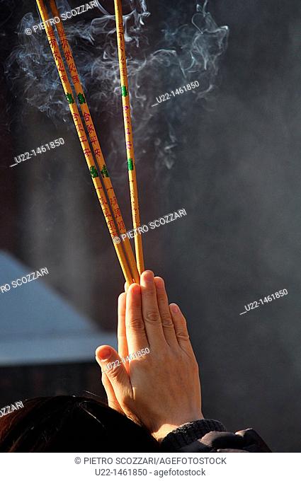 Beijing (China): a person prays burning incense at the Dongyue Temple during the Spring Festival