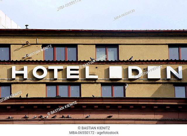 An old nostalgic hotel facade with pigeons on the roof