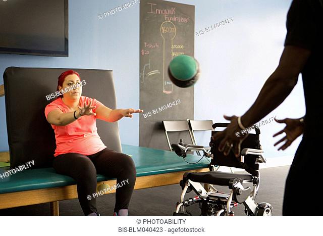 Mujer discapacitada haciendo fisioterapia con entrenador