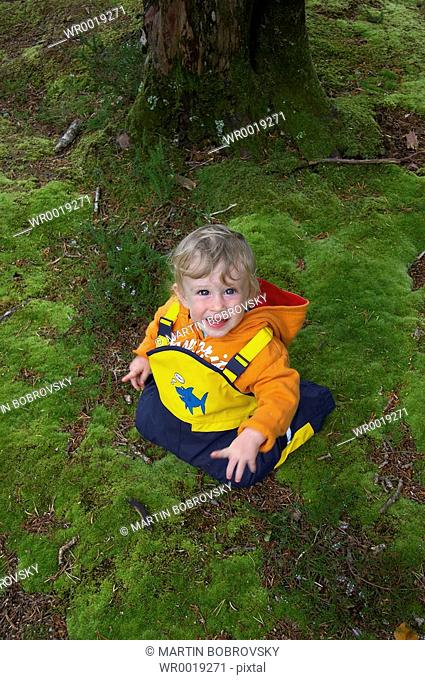 baby on mossy forest soil