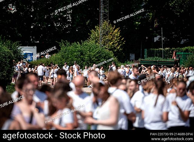 30 July 2022, North Rhine-Westphalia, Neuss: Visitors line up in front of the entrance. The ""Farbgefühle"" festival, also called the ""Holi Festival of Colours