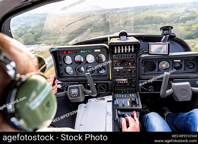 Pilot and copilot navigating sports plane, rear view