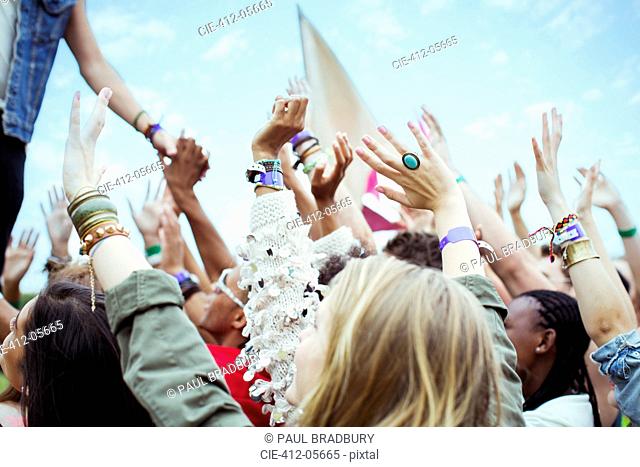 Fans reaching to shake hands with performer at music festival