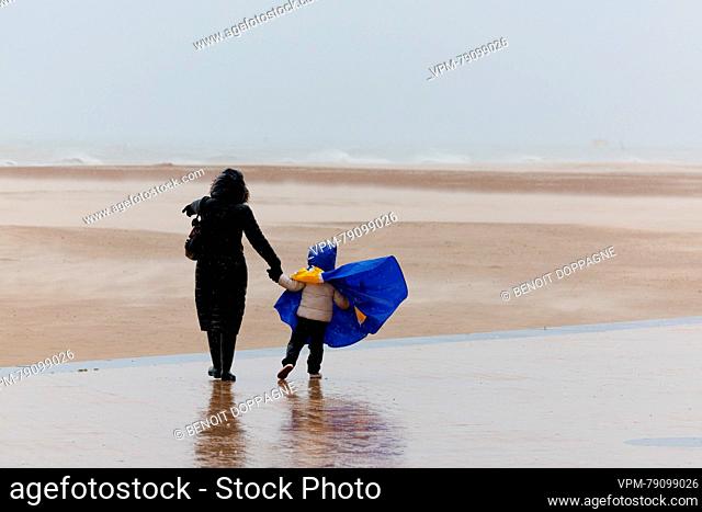 Illustration shows a woman and a child walking on the dike along the beach as the storm Ciaran is expected with heavy winds, in Oostende