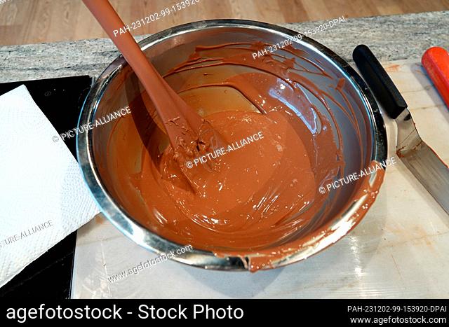 PRODUCTION - 13 November 2023, Switzerland, Broc: Melted chocolate in the show kitchen of the Cailler chocolate factory in Broc in the Swiss canton of Fribourg...