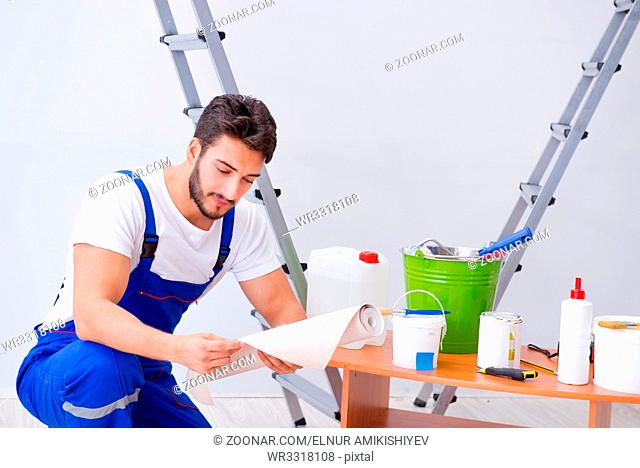 Repairman doing renovation repair in the house with paper wallpaper