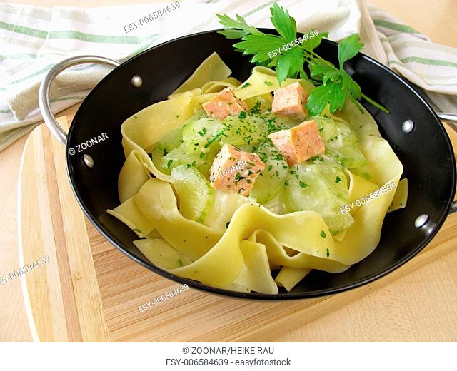 Pasta with cucumber and salmon in wok