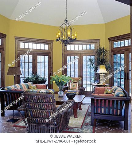 SUNROOMS: Octagon shaped sunroom with high ceilings, transoms, french doors, golden ochre colored walls, indoor outdoor furniture, tile floor, warm