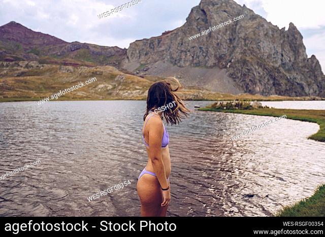 Young woman wearing bikini standing in lake of Ibones of Anayet