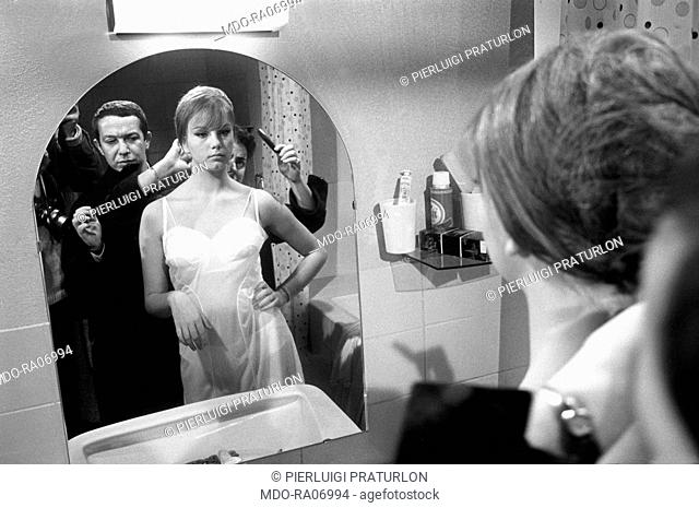 Italian set designer Danilo Donati checking Italian actress Stefania Sandrelli's hair on the set of the film La bella di Lodi. 25th November 1962