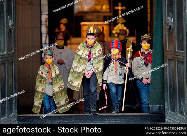 dpatop - 29 December 2020, North Rhine-Westphalia, Aachen: The carol singers come out of Aachen Cathedral after a church service to kick off the 2021 Epiphany...