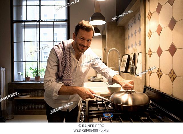 Portrait of smiling man cooking at home