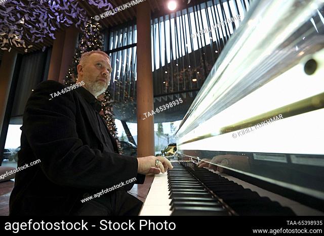 RUSSIA, ALTAI REPUBLIC - DECEMBER 1, 2023: A man plays a piano at the 5* Hotel at the Manzherok ski resort on the eve of its opening