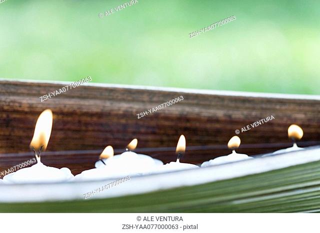Lit votive candles in natural setting