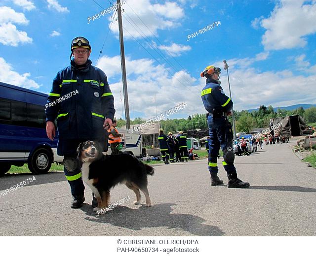 Johannes Arnoldi (l) of the German Federal Agency for Technical Relief (THW) and search dog Cash participate in an earthquake drill in Epeisses near Geneva