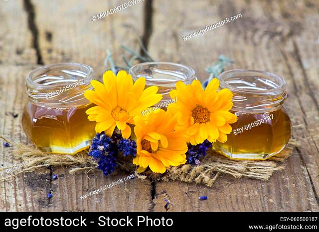 honey and flowers on wooden background