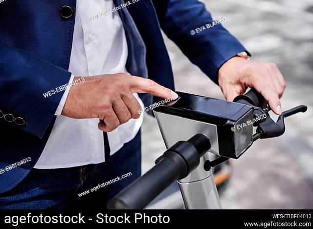 Businessman using electric push scooter