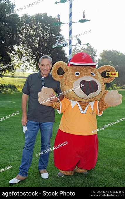 12 September 2020, Bavaria, Tutzing: Actor and host Michael Roll is standing with the mascot Bolli Bear at the Tutzing Golf Club on Lake Starnberg at the...