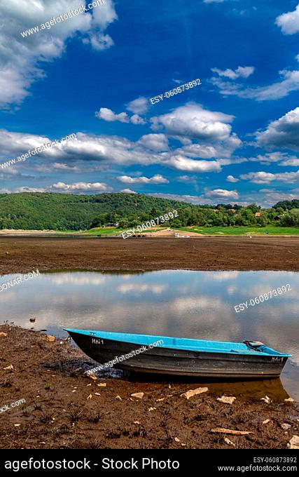Ruderboot auf dem Seeboden im Edersee bei niedrigem Wasserstand. Boat on the sea ground at very low water levels in the Edersee in northern Hesse, Germany