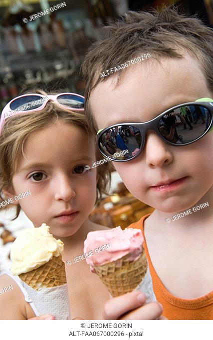 Young siblings eating ice cream cones