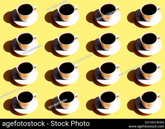 Pattern of white cup and saucer plate of black espresso coffee top view with shadow of sun on beige terracotta background. High quality photo