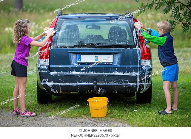 Boy and girl washing car