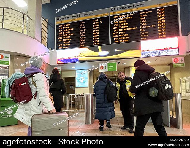 RUSSIA, ST PETERSBURG - DECEMBER 14, 2023: Travellers show their tickets before boarding a Helsinki-bound bus operated by Ecolines at a bus station before its...