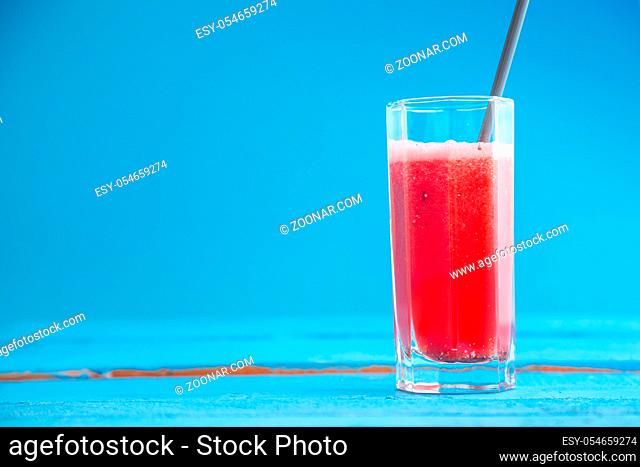 smoothies, freshly squeezed watermelon juice in a transparent glass on a blue wooden background