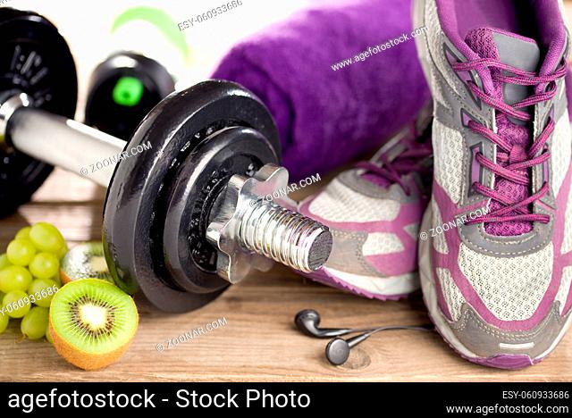 Fitness-Equipment mit Hantel, Turnschuhen und gesundem Snack