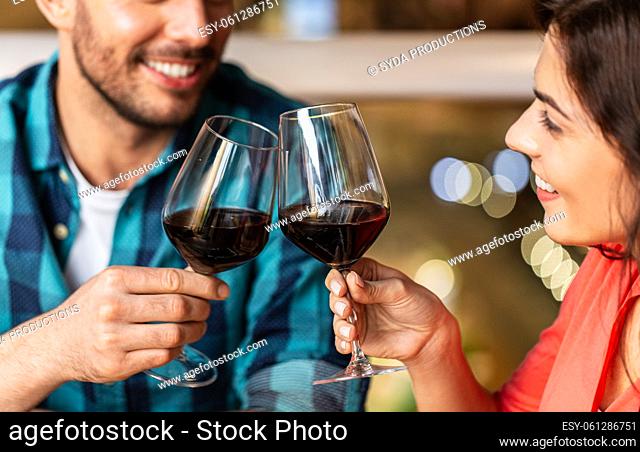 close up of couple drinking red wine at restaurant