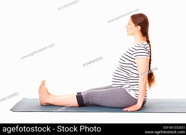 Pregnancy yoga exercise - pregnant woman doing yoga asana Dandasana Staff pose isolated on white background