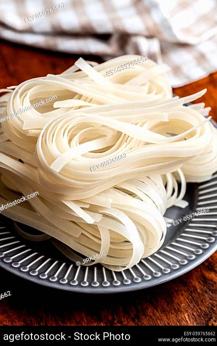 Dried white rice noodles. Raw pasta. Uncooked noodles on plate
