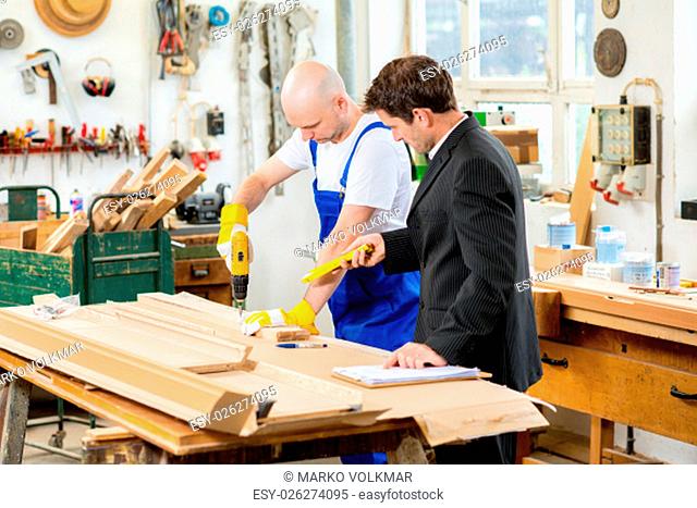 boss and worker together in a carpenter's workshop