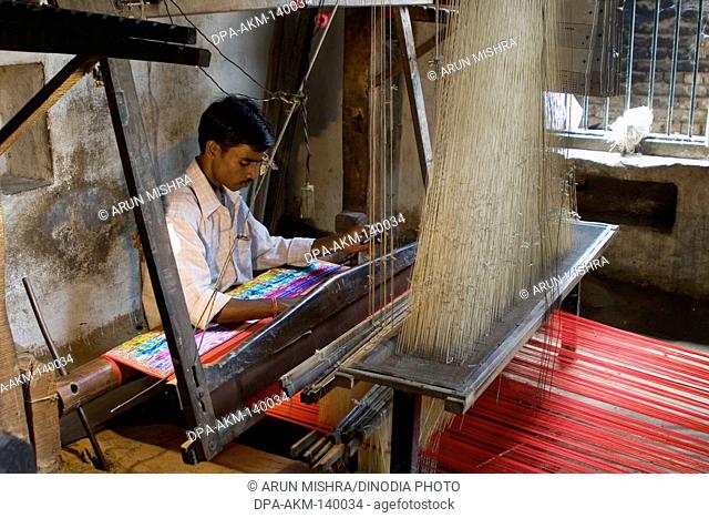 Weaver weaving Varanasi sari silk thread with handloom in Varanasi ; Uttar Pradesh ; India