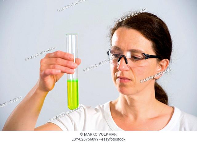 dark haired female lab assistand with test tube