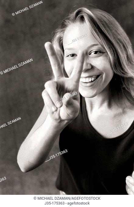 Woman makes 'Peace' sign with fingers