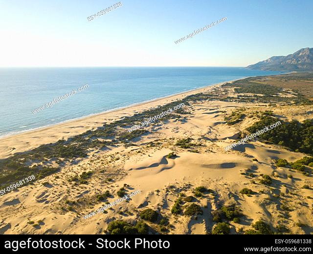Drone aerial view of massive sand dune mountain behind sea coast beach in Patara, Turkey