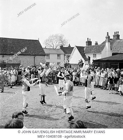 The Westminster Morris performing a handkerchief dance in front of a crowd of people standing in The Swan Hotel courtyard