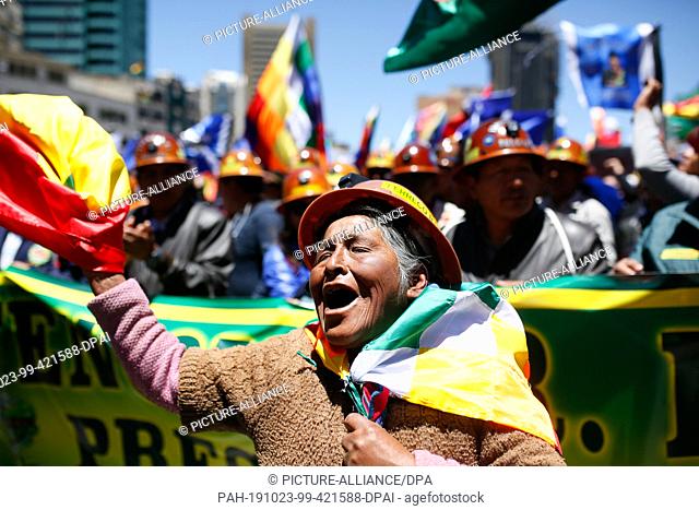 23 October 2019, Bolivia, La Paz: A woman waving the flag of Bolivia and shouting political slogans at a rally in support of President Morales