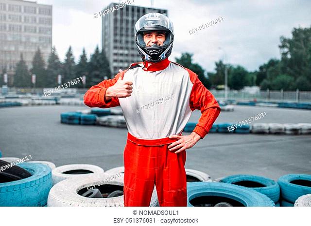 Kart driver in helmet, karting track on background. Go-kart motor sport