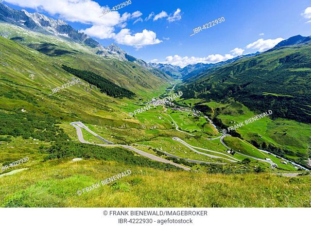 Road leading to Furka Pass, hairpin bends along the mountain slope, green fields at the bottom of the valley, Tiefenbach, Uri, Switzerland
