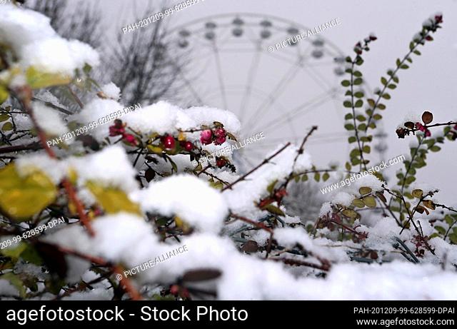 09 December 2020, Bavaria, Bad Wörishofen: The Ferris wheel of the ""Skylinepark"" amusement park stands in the snow-covered landscape