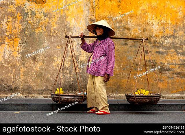 Old Woman from Vietnam is selling fruits in the Streets of Hoi An
