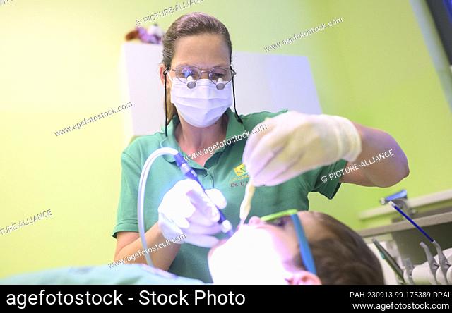 PRODUCTION - 11 September 2023, Lower Saxony, Hanover: A pediatric dentist examines a three-year-old child in a pediatric dental practice
